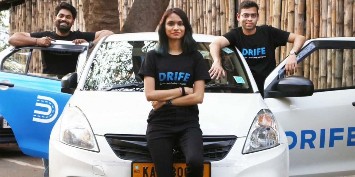 3-people-stand-at-a-car-with-the-drife-logo-on-it-smiling-at-the-camera.jpg